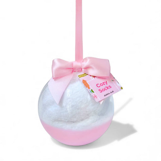 Dabble Doll Cozy Socks displayed in a decorative pink ornament with a bow and tag