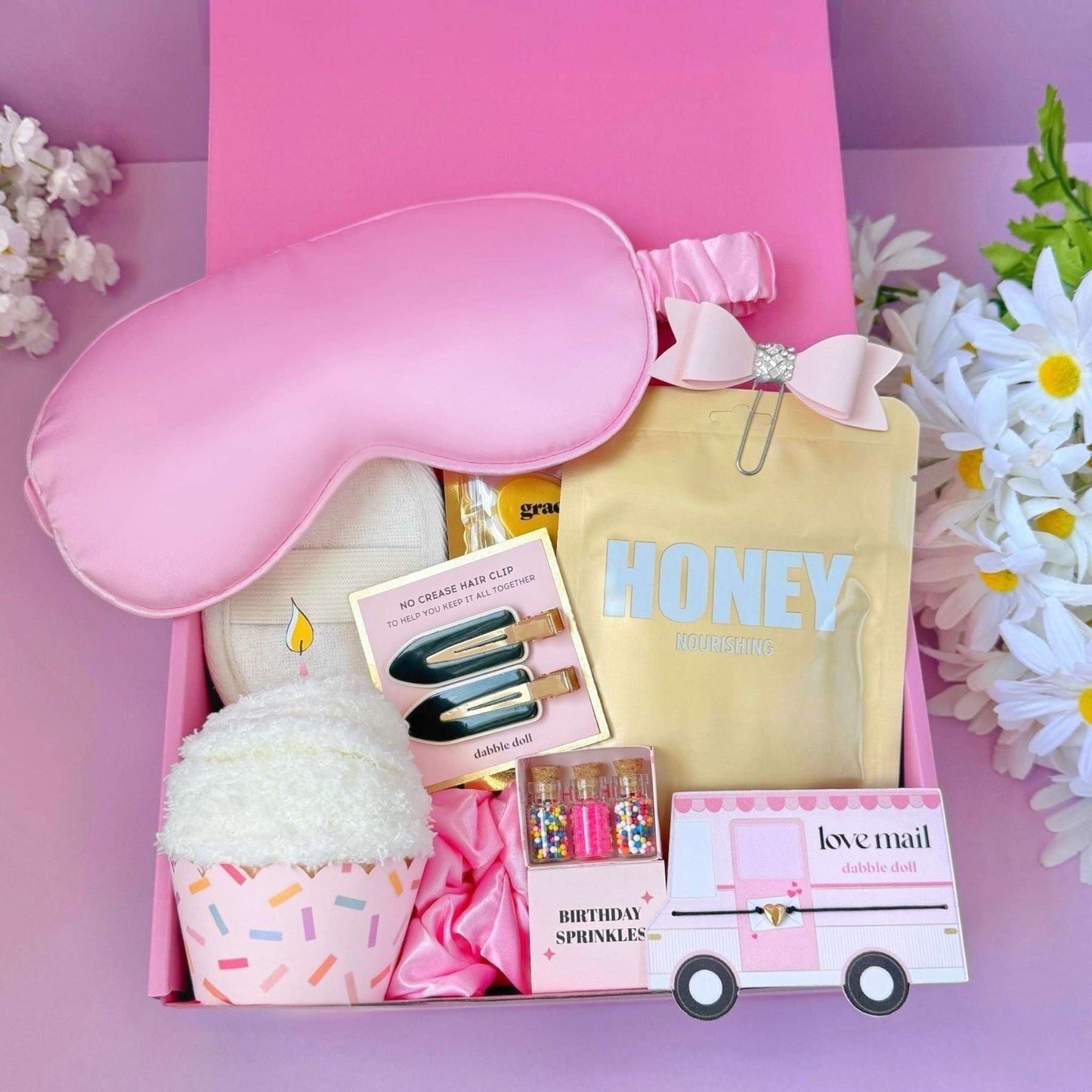 Dabble Doll birthday gift socks box with pink eye mask, hair clips, cozy socks, and birthday sprinkles