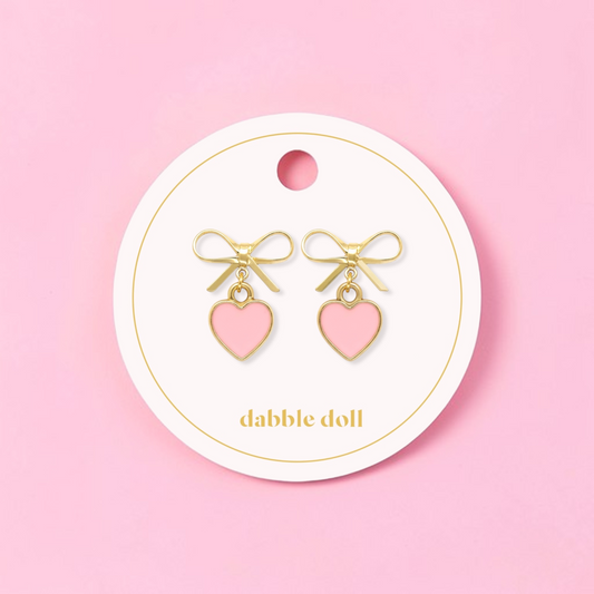 Dabble Doll bow earrings featuring gold accents and pink heart charms for a cute accessory look