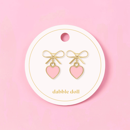Dabble Doll bow earrings featuring gold accents and pink heart charms for a cute accessory look