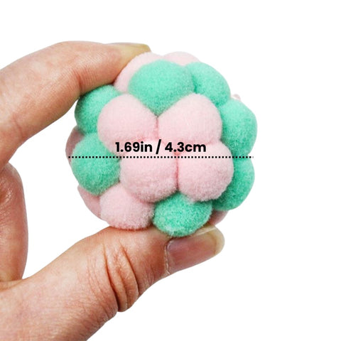 Hand holding a green and pink cat plush toy balls measuring 1.69 inches in diameter