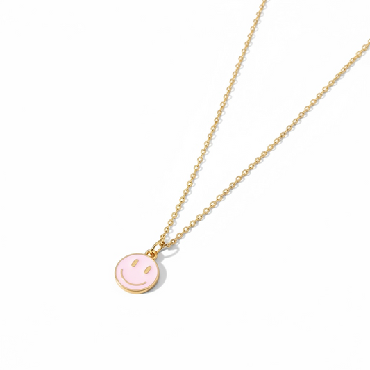 Dabble Doll charm and necklace featuring a smiling face pendant in gold and pink