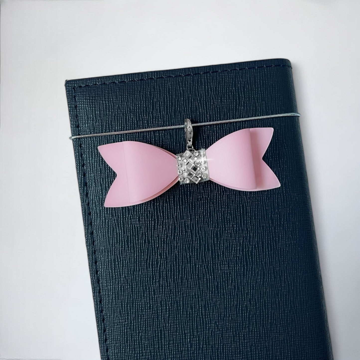 Light Pink Bow Charm for Purse with Silver Accent on a Dark Blue Wallet