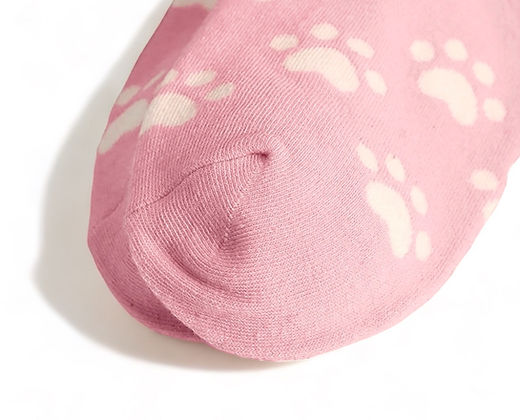 Close-up of cute pink cat socks with white paw print pattern by Dabble Doll