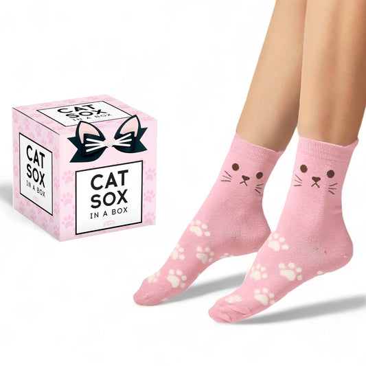 Cute pink cat socks with cat face and paw prints worn on feet beside Cat Sox in a Box packaging