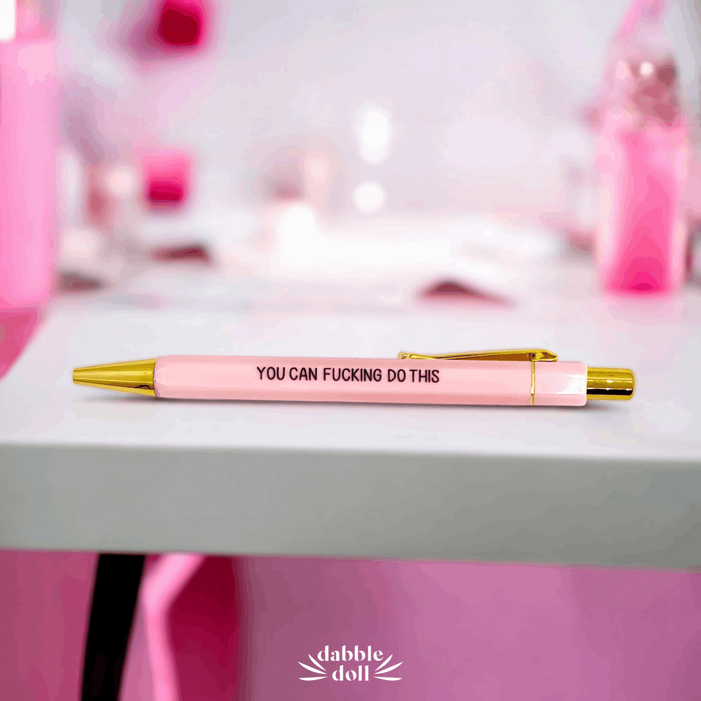 Pink pen with gold accents on a table from Dabble Doll badass bitch motivational jar gift box