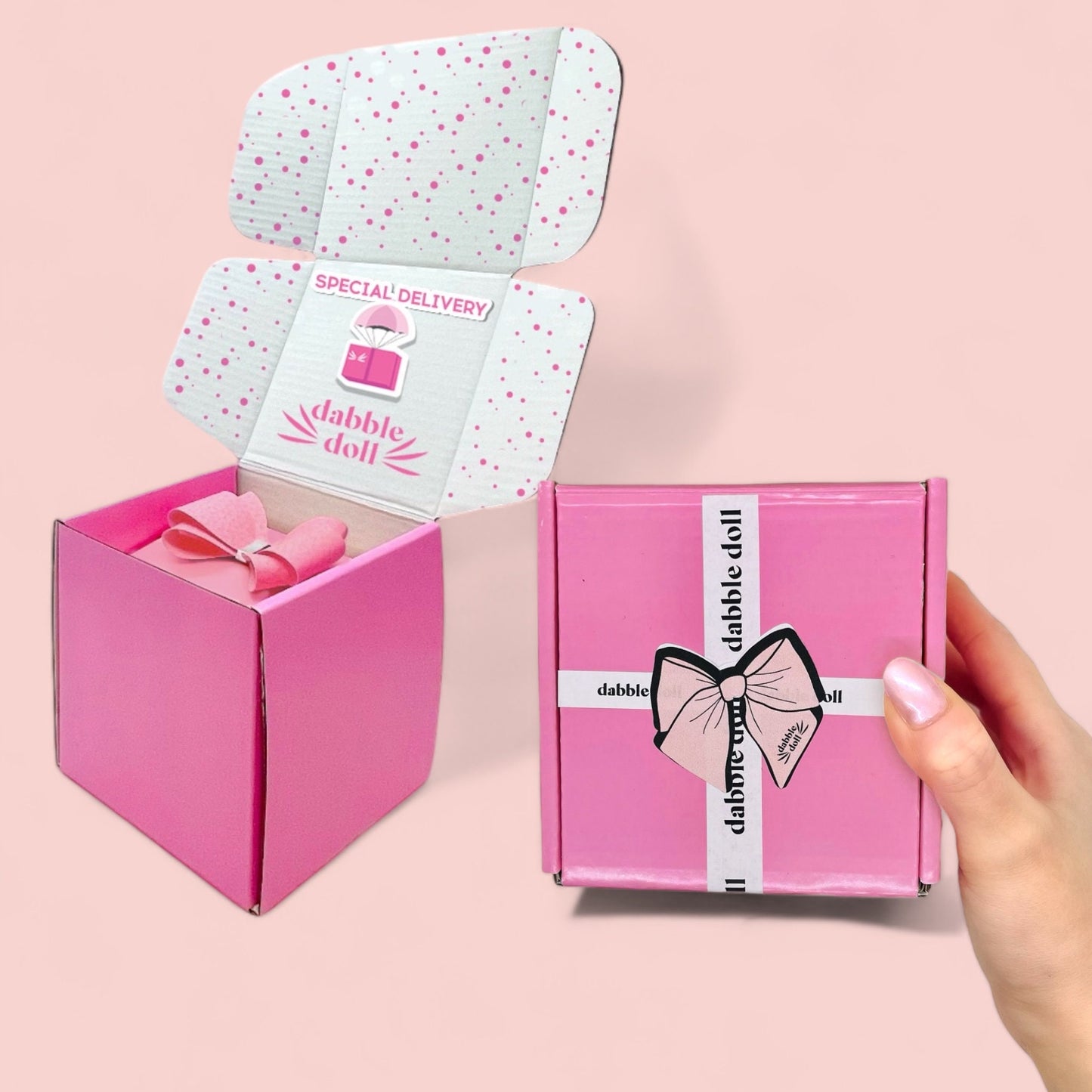 Dabble Doll pink cat socks gift box with bow and special delivery packaging held in hand