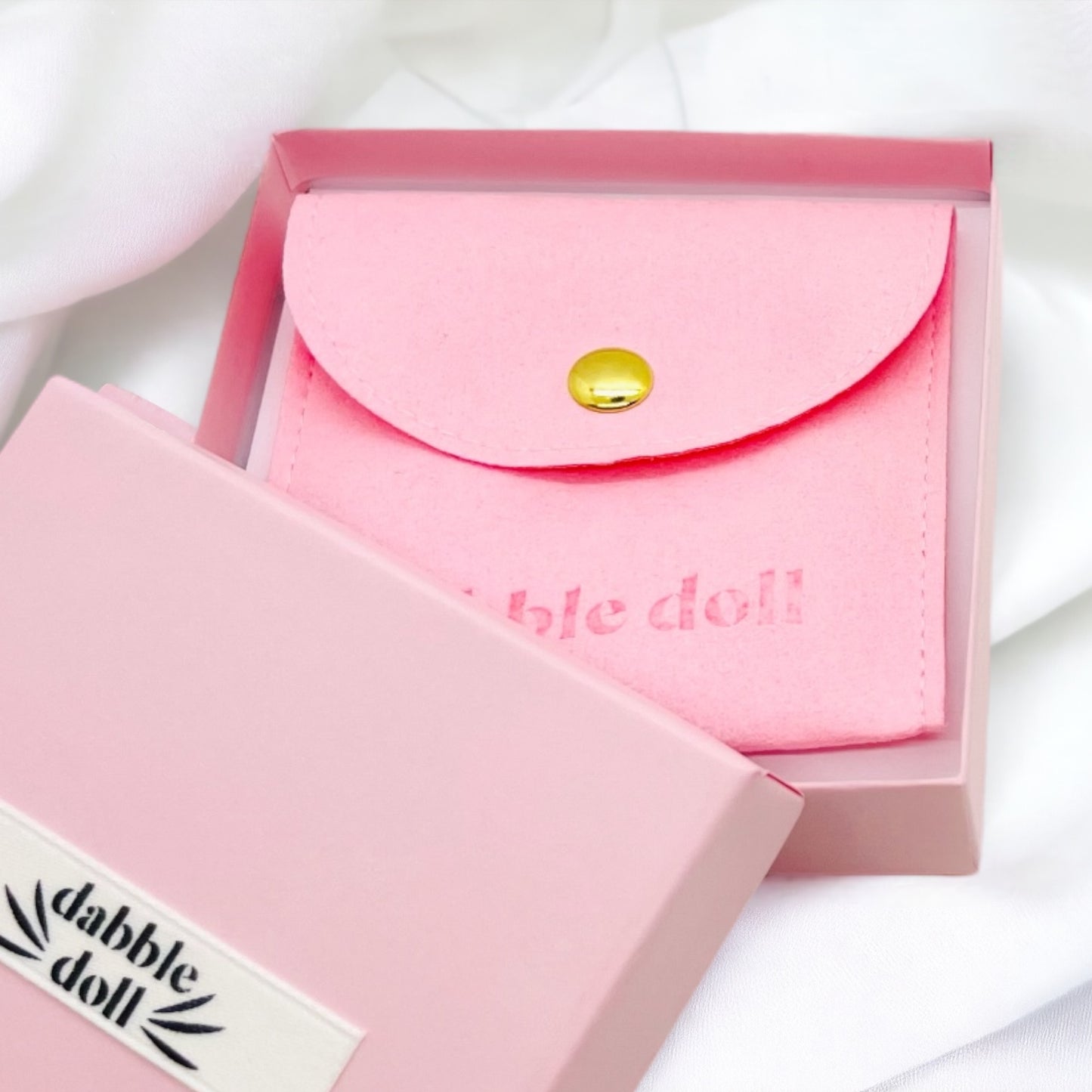 Dabble Doll pink suede pouch in a pink box for storing creaseless clips for styling