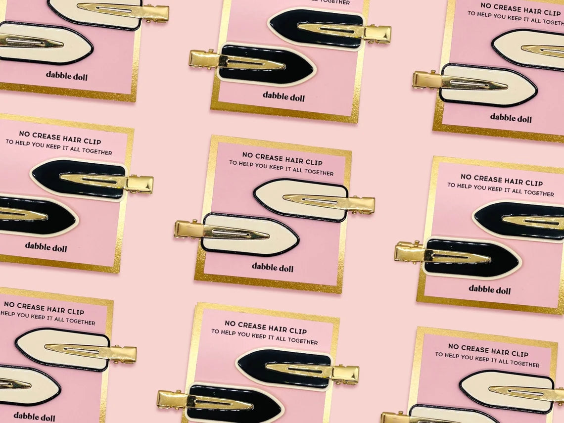Dabble Doll creaseless hair clips in black and cream on pink and gold packaging