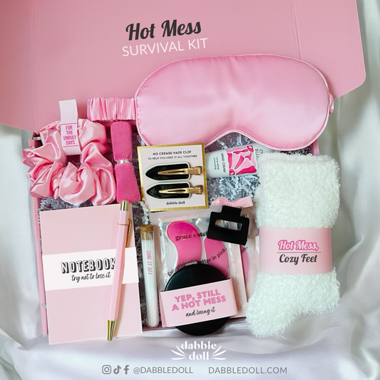 Dabble Doll hot mess survival kit gift box with pink sleep mask, cozy socks, hair clips, and notebook