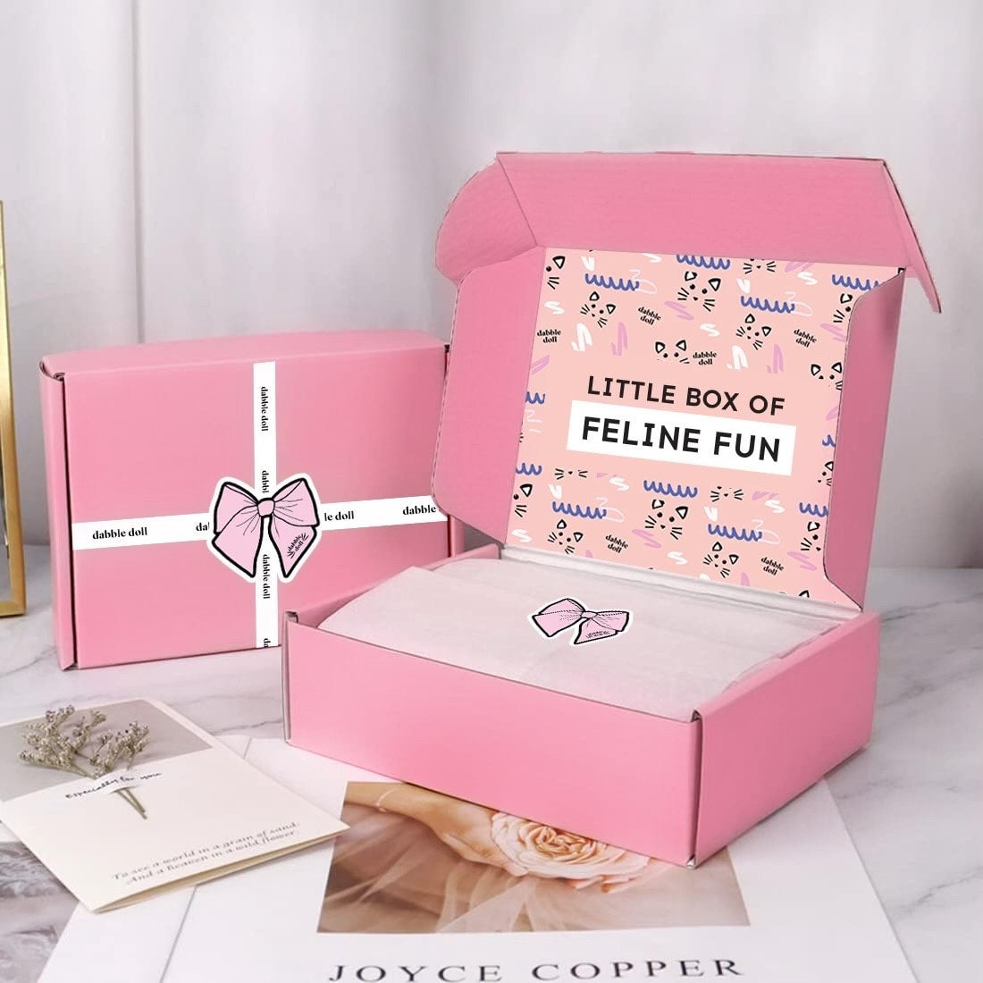 Dabble Doll luxury cat toy gift box in pink with playful packaging and white ribbon bow