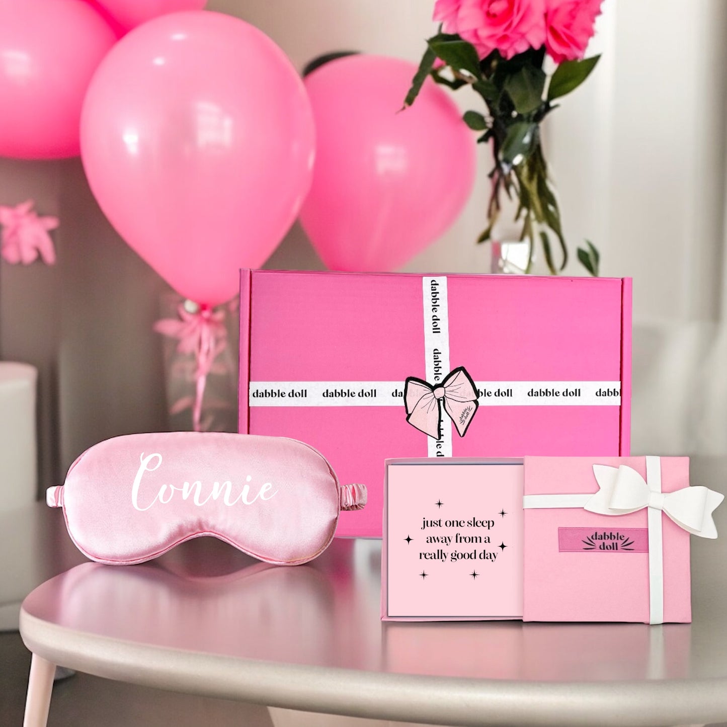 Dabble Doll gift box with pink silky sleep mask personalized with name Connie and pink balloons background