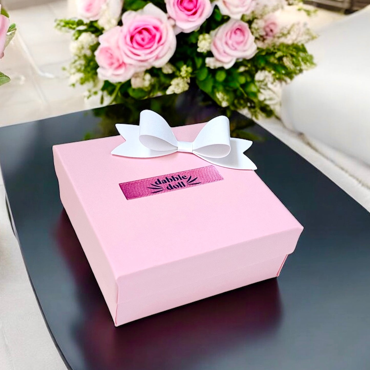 Dabble Doll pink gift box with white bow, perfect for packaging a pink silky sleep mask