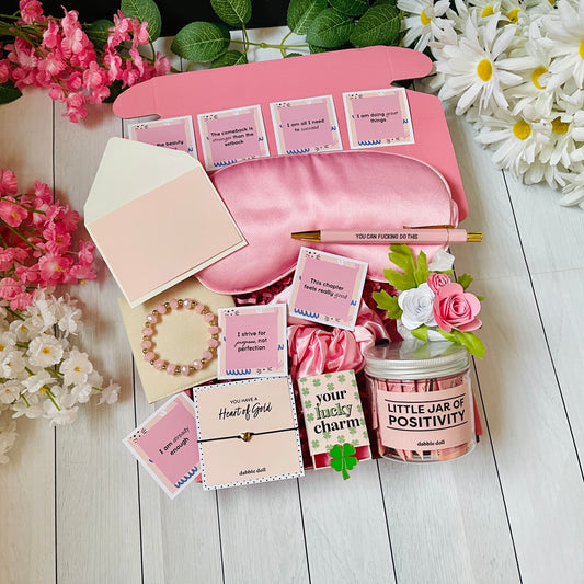 Dabble Doll positivity care package gift box with sleep mask, bracelet, jar of positivity, flowers, and motivational cards