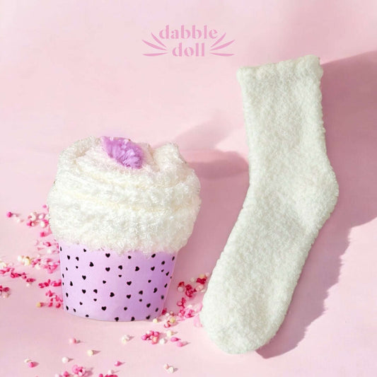 Dabble Doll self care gift set with mug featuring cozy white socks and soft towel in a purple cup