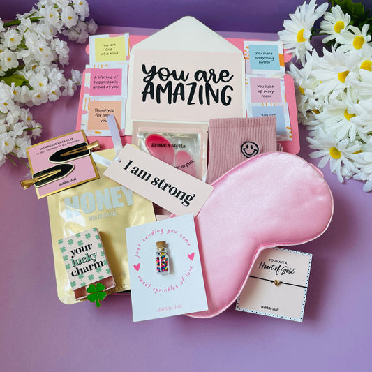 Pink gift in box for women featuring a sleep mask, charm, and inspirational cards