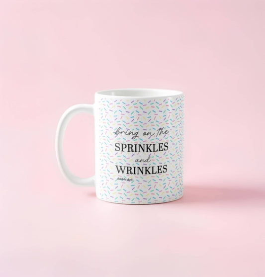 Dabble Doll coffee mug with colorful sprinkles design and the text Bring on the Sprinkles and Wrinkles