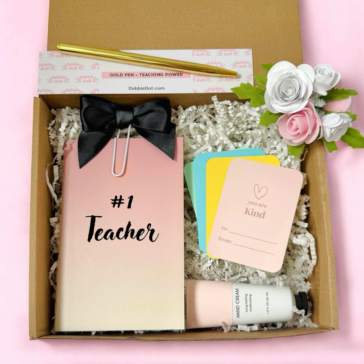 Dabble Doll teacher gift set with #1 Teacher notebook, gold pen, hand cream, colorful cards, and decorative flowers