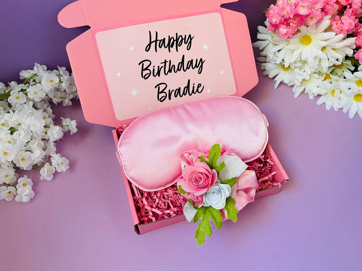 Personalized gifts for girls featuring a pink satin sleep mask with floral accents in a gift box