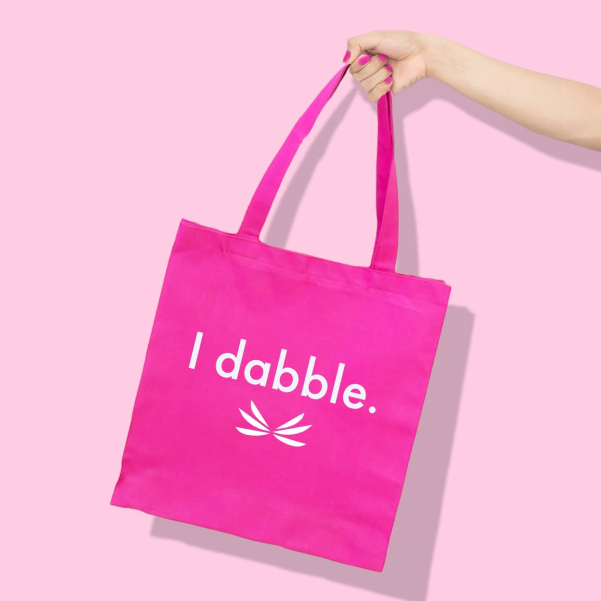 Bright pink canvas tote bag with the phrase I dabble, perfect for girls and women in the athleisure collection