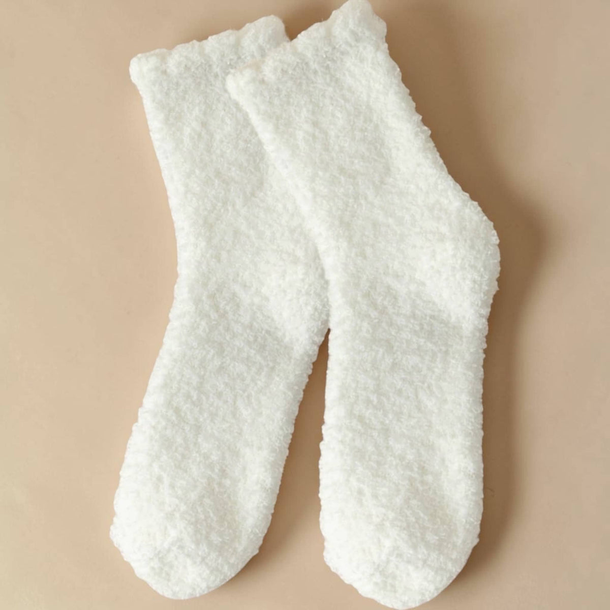 Pair of white textured socks on a beige background