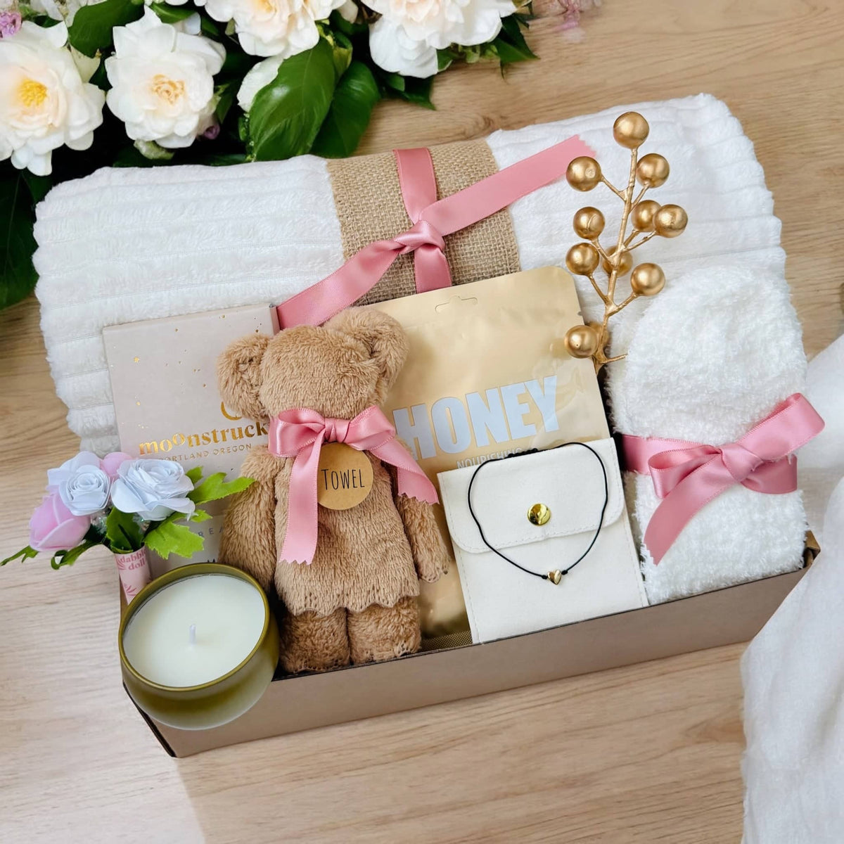Romantic ready-to-gift box with plush teddy bear towel, scented candle, white towels, honey packet, and decorative flowers