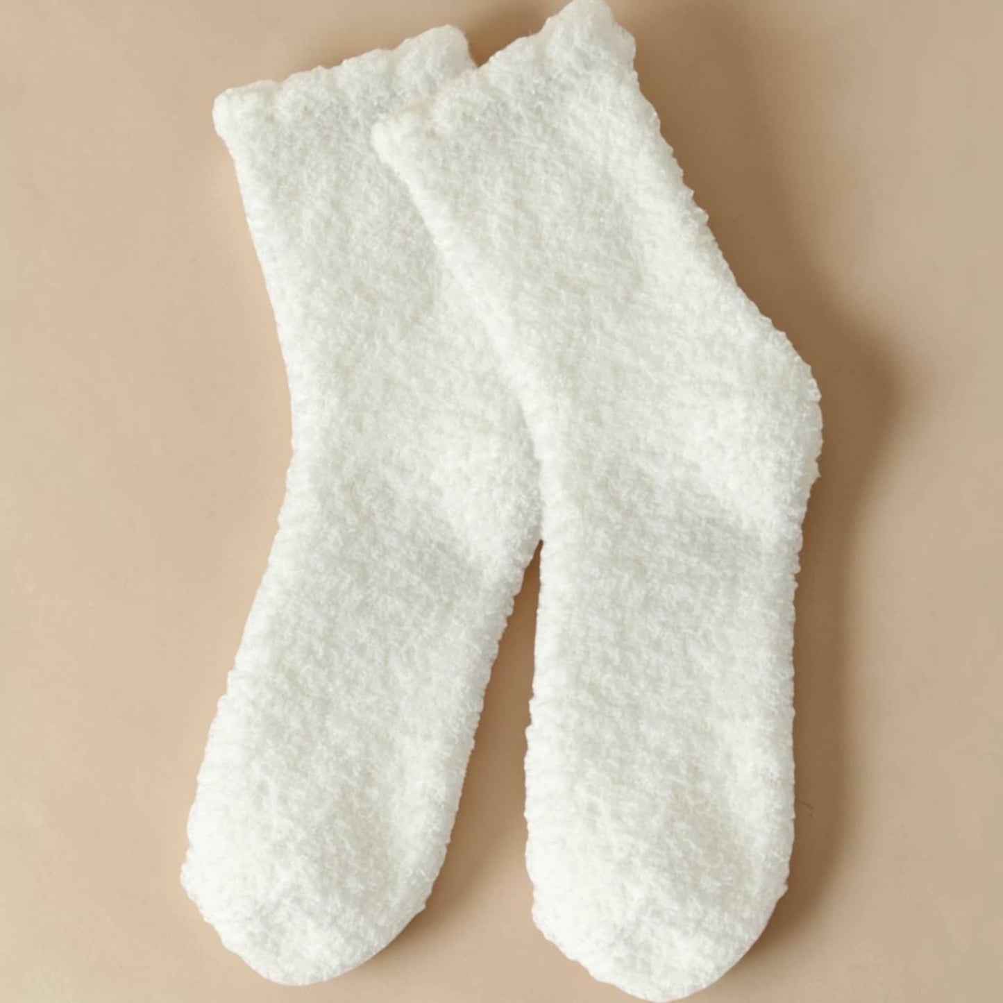 Pair of white textured socks on a beige background