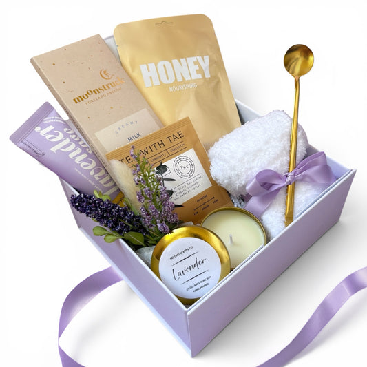 Gift box with lavender-themed products including a candle, honey, and bath items.