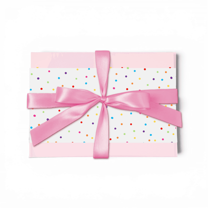 Gift box with colorful polka dots and a pink ribbon on a white background