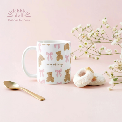 Mug with teddy bear and bow pattern on a pink background with flowers and a spoon.
