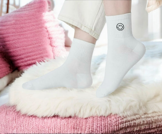 White socks with smiley face design on a pink and white surface