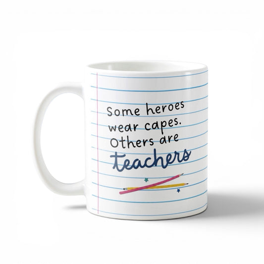 Mug with lined paper design and text 'Some heroes wear capes. Others are teachers' on a white background