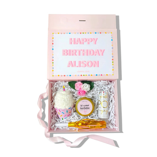Dabble Doll Birthday Gift Box featuring decorations, candles, and personalized items for a festive celebration