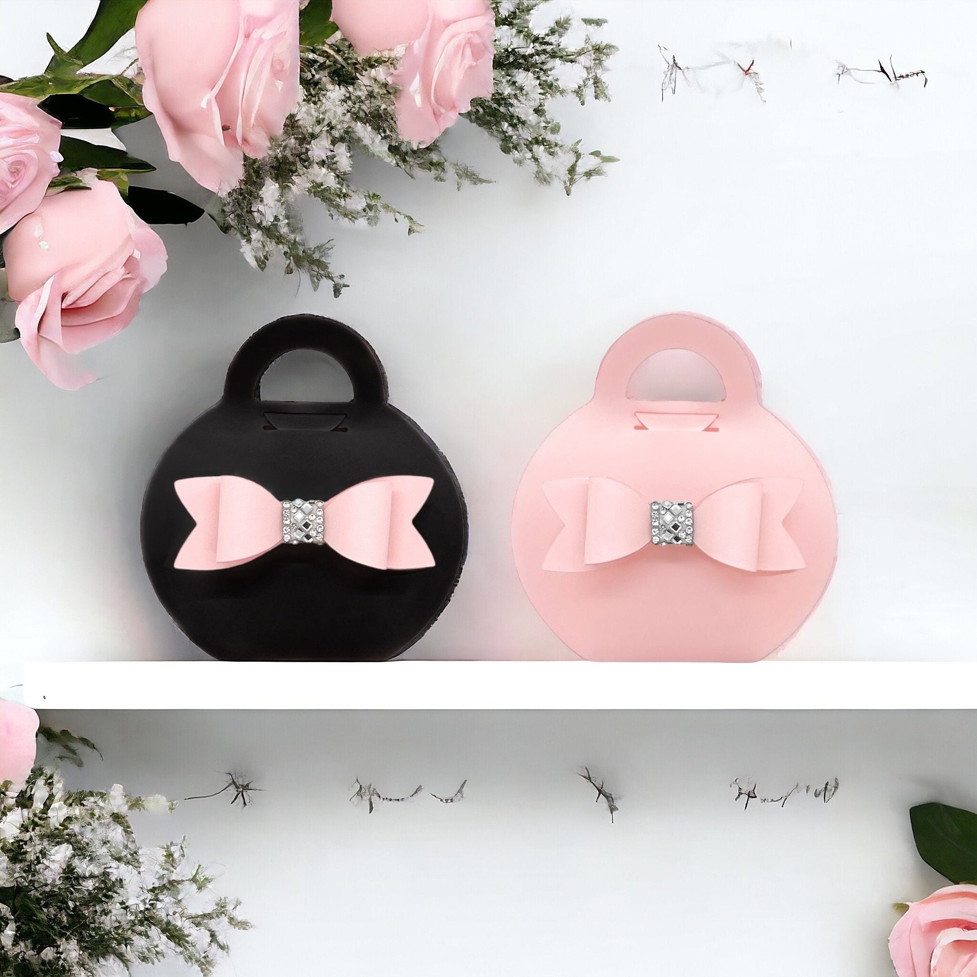 Dabble Doll black purse favor bags with pink bow and rhinestone detail displayed with pink roses