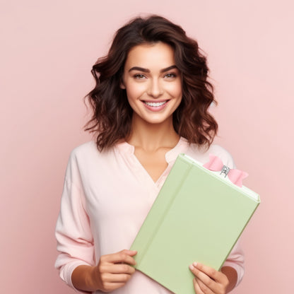 Smiling woman holding a green book featuring a pink bow bookmark for stylish reading