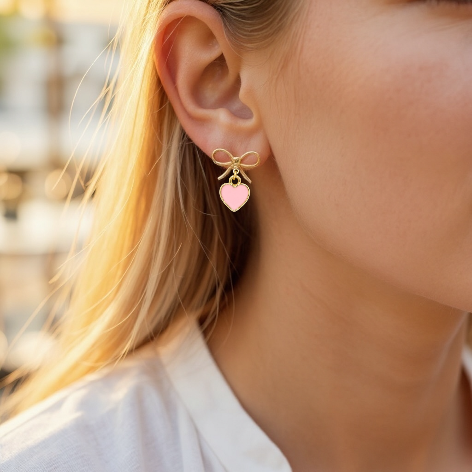 Dabble Doll bow earrings featuring a pink heart charm and gold accents for a stylish look