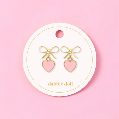 Dabble Doll bow earrings featuring gold accents and pink heart charms for a cute accessory look