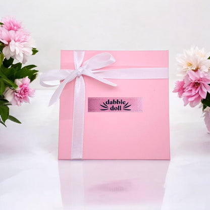 Dabble Doll gift box with ribbon, perfect for charm and necklace presentation