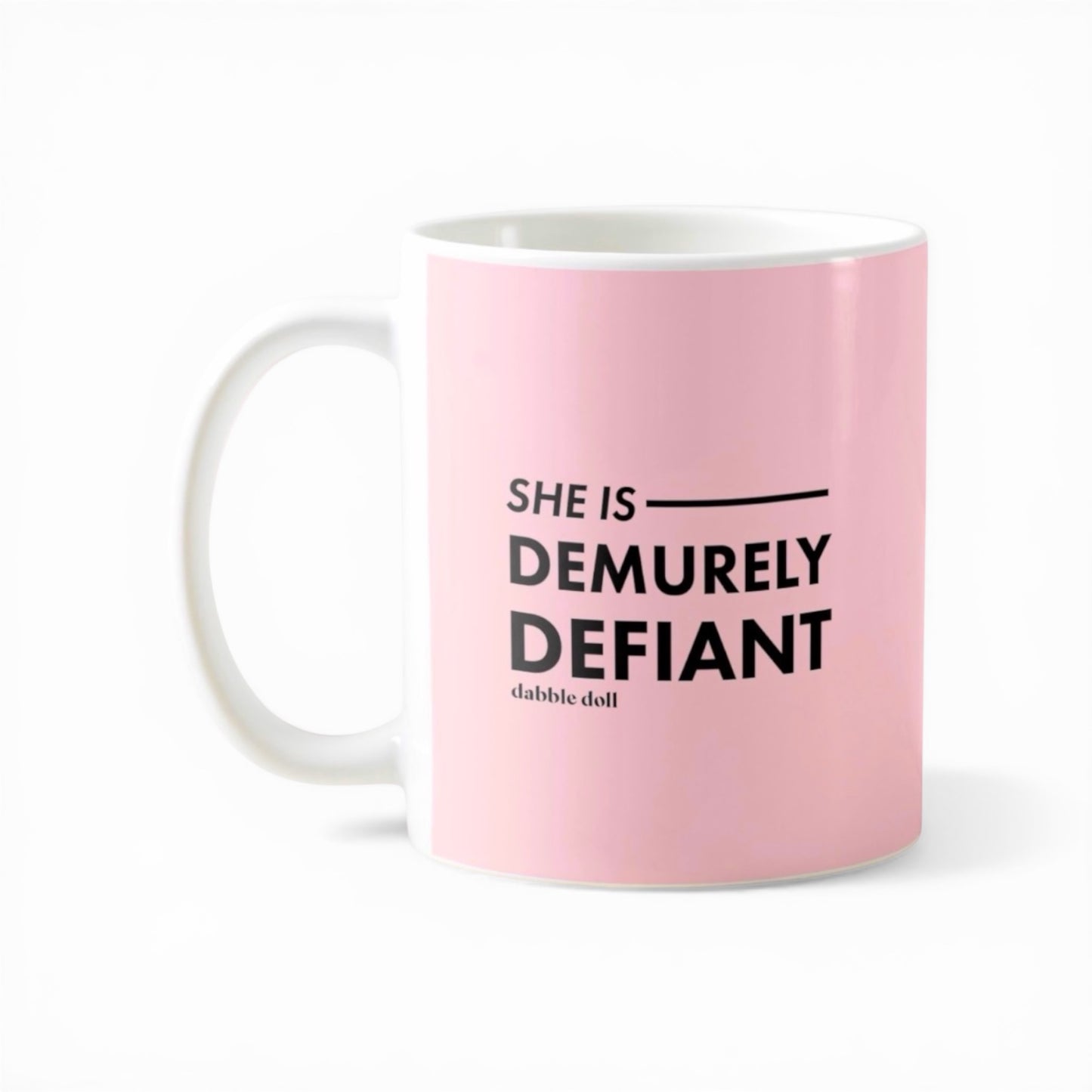 Dabble Doll pink coffee mug featuring the phrase She Is Demurely Defiant for a bold gift idea