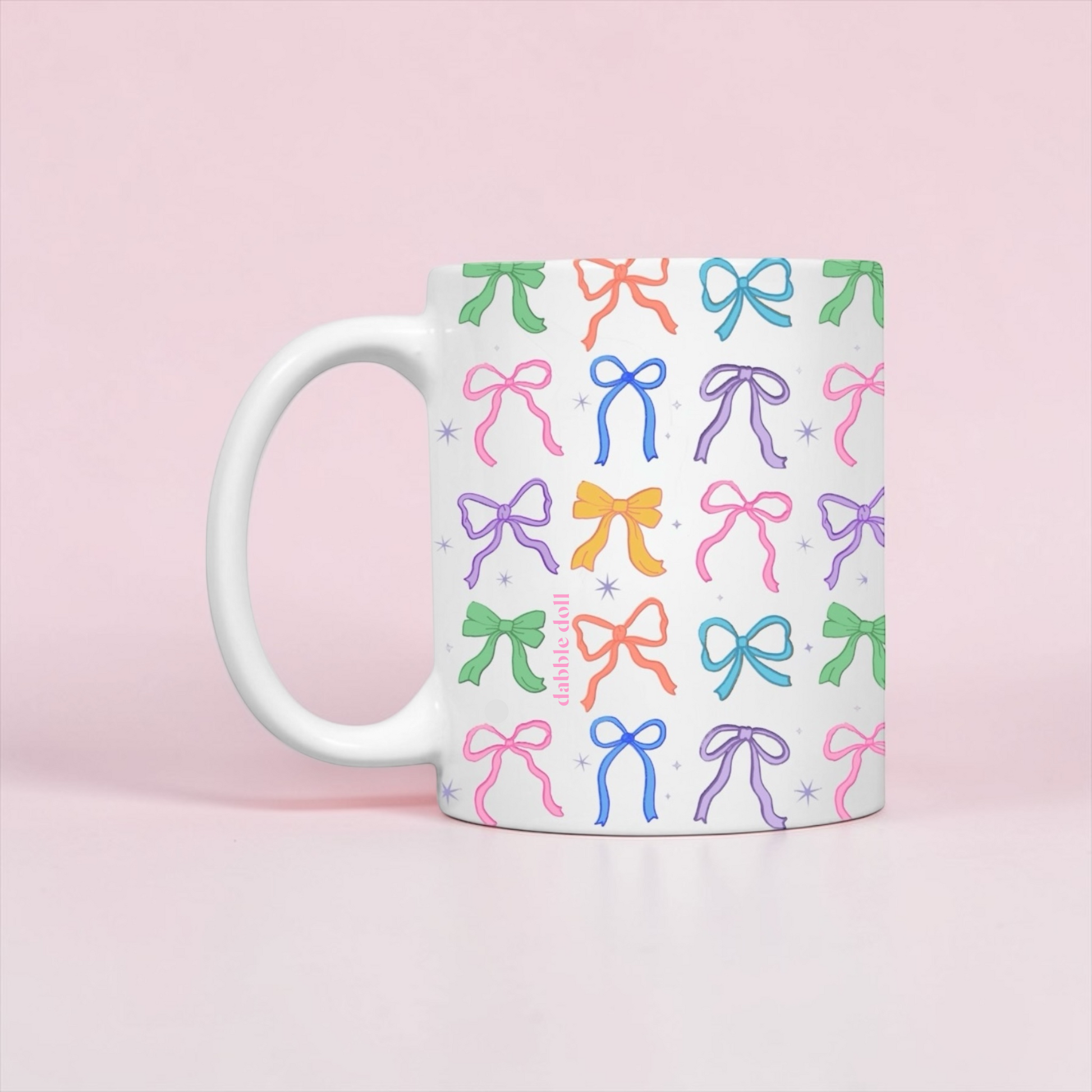 Dabble Doll Coquette mug featuring colorful bow designs on a white background