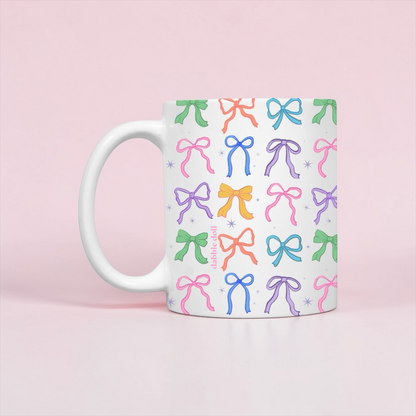 Dabble Doll Coquette mug featuring colorful bow designs on a white background