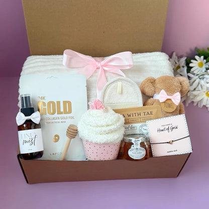 Dabble Doll cozy pampering gift set with plush towel, gold facial mask, linen mist, bath sponge, and honey jar