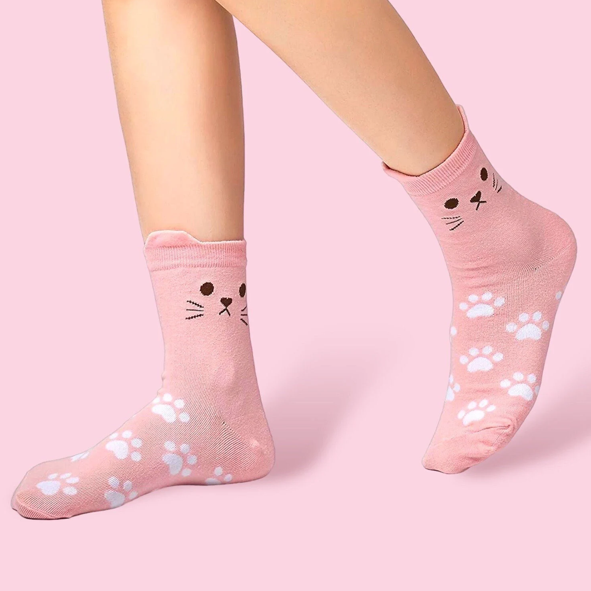 Cute pink cat socks with paw prints and cat face design by Dabble Doll on model feet