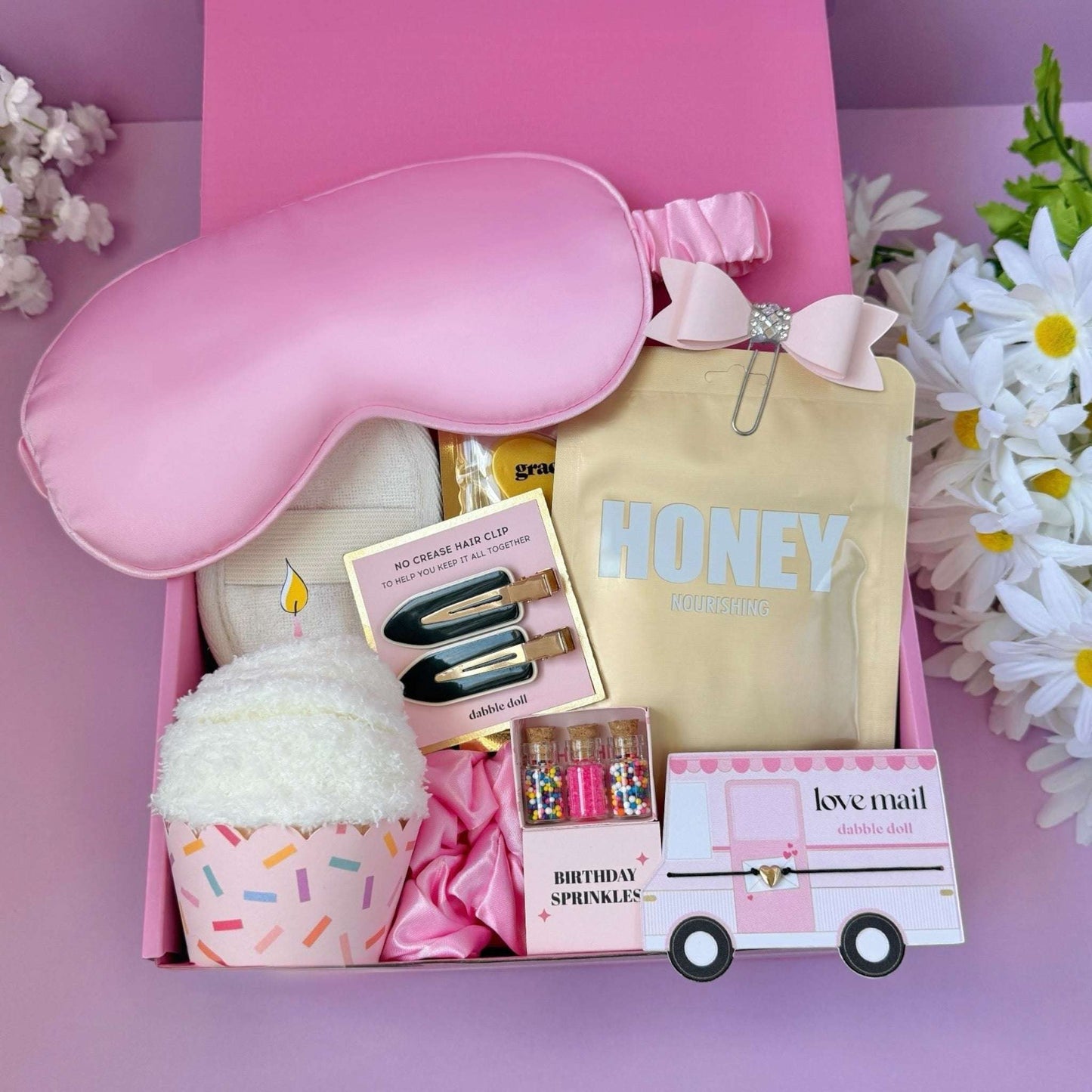 Dabble Doll birthday gift box featuring a sleep mask, cupcake bath bomb, and colorful sprinkles