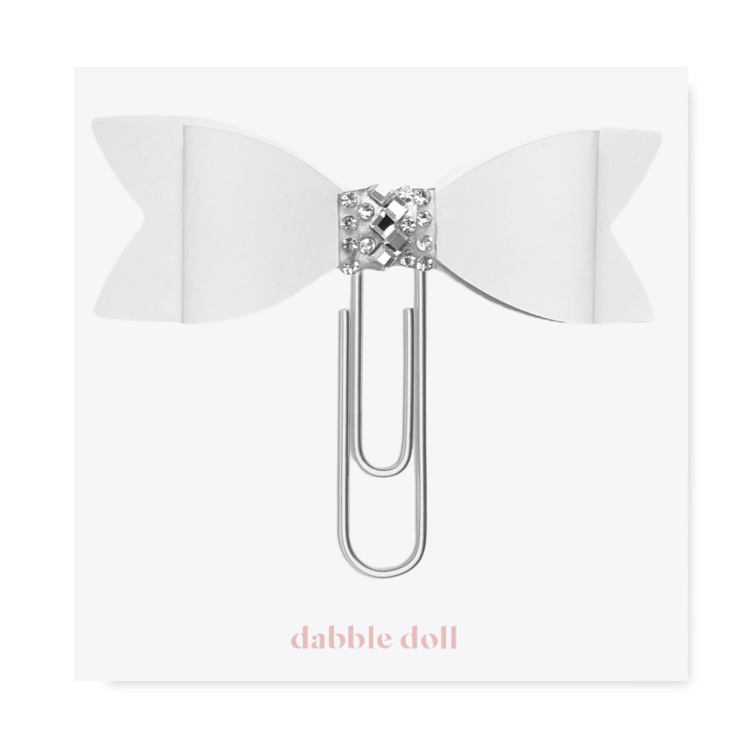 Dabble Doll Bow paperclip featuring a white bow design and decorative silver accents