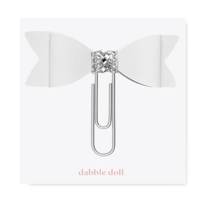 Dabble Doll Bow paperclip featuring a white bow design and decorative silver accents