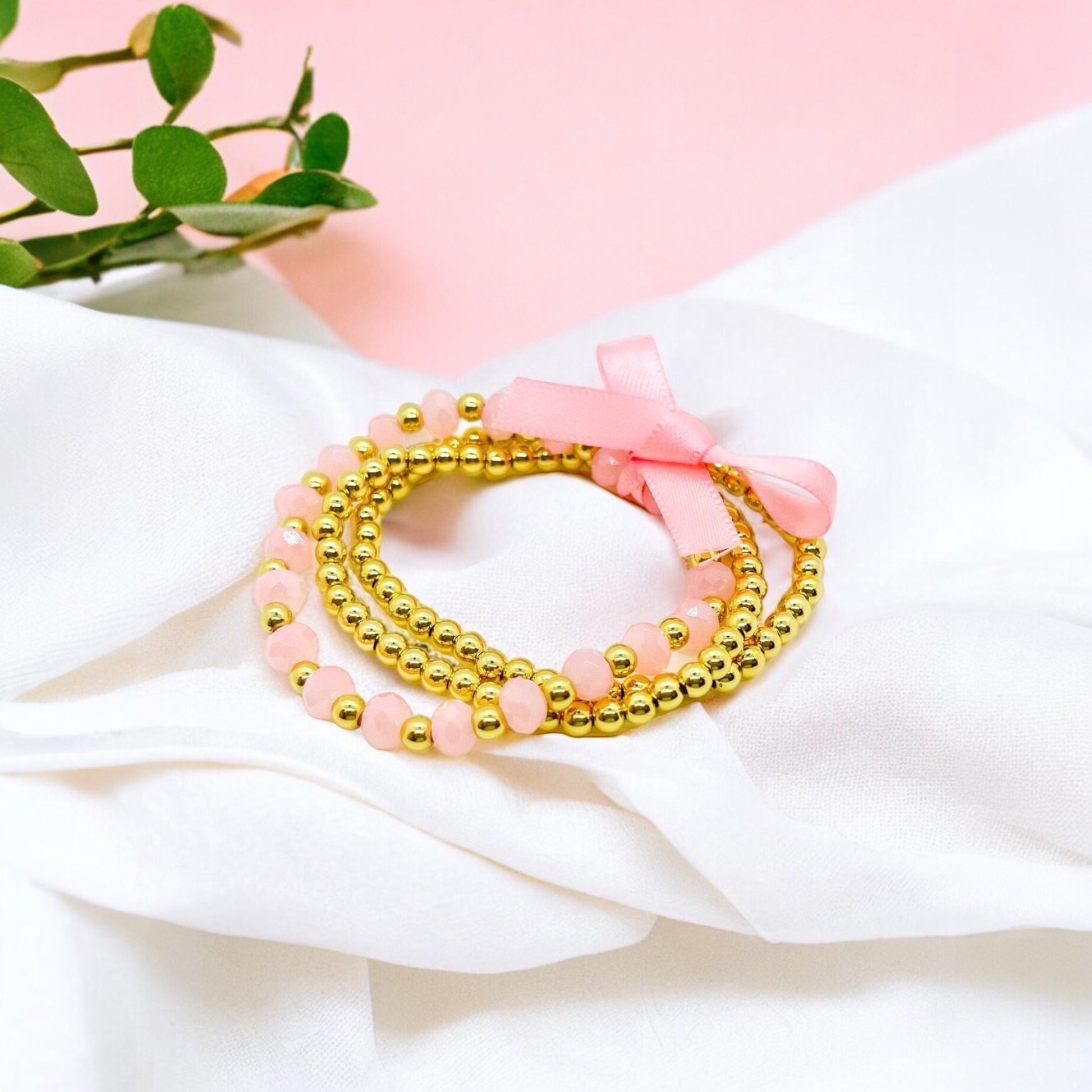 Pink and gold Dabble Doll bracelet stack for girls with beads and a bow for a stylish accessory