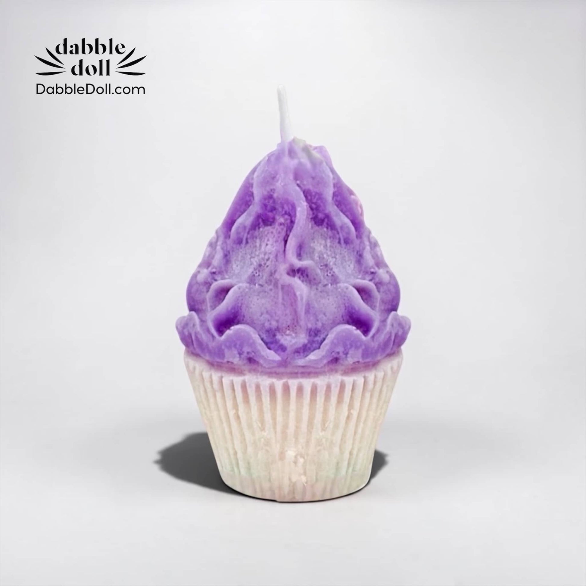 Dabble Doll Candle shaped like a purple cupcake with detailed frosting design