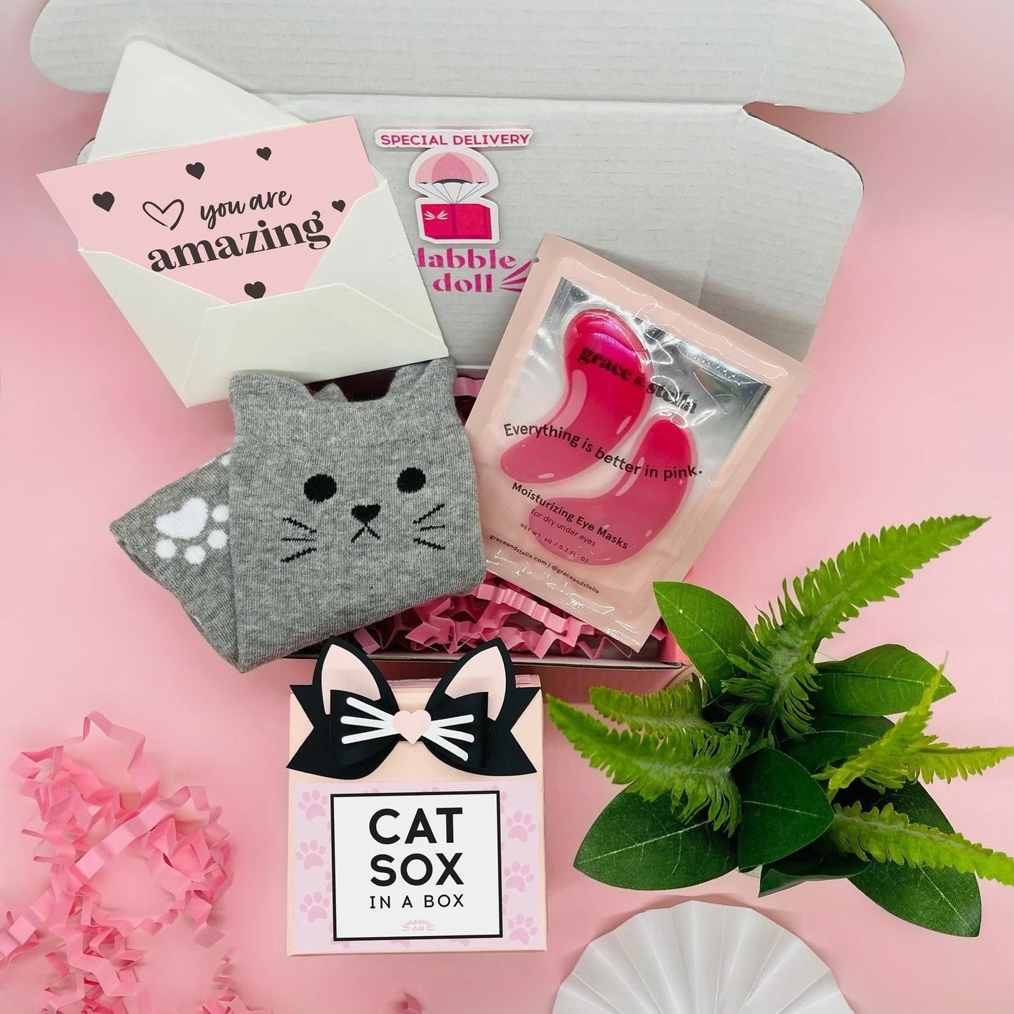 Dabble Doll cat socks gift box with gray cat face socks, moisturizing gel masks, and a cute greeting card