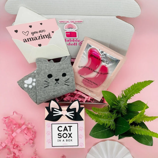 Dabble Doll cat socks gift box with gray cat face socks, moisturizing gel masks, and a cute greeting card
